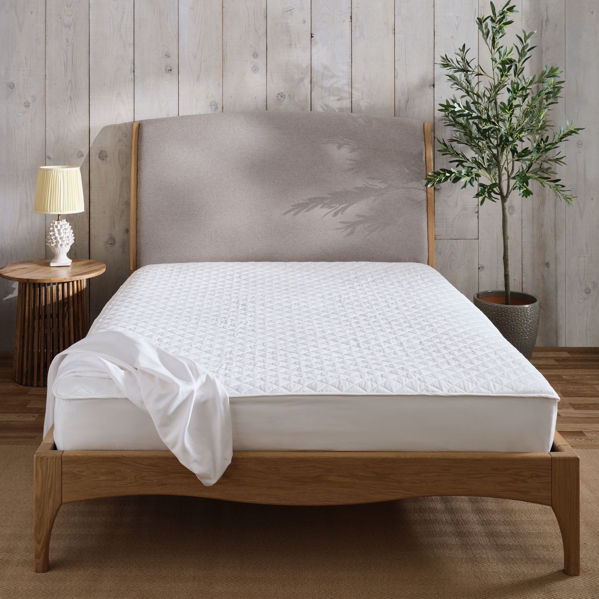Mattress protector on a mattress and bed. | Scooms