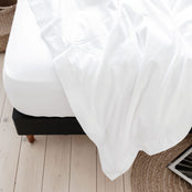 Luxurious white Egyptian cotton sheet on a bed with the top sheet pulled back. Scooms