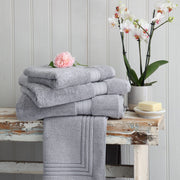 Silver grey Egyptian cotton towels and bath mat on a wooden bench. Scooms