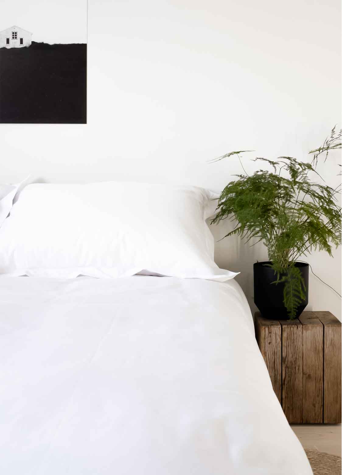 White cotton bedding on bed with plant | scooms