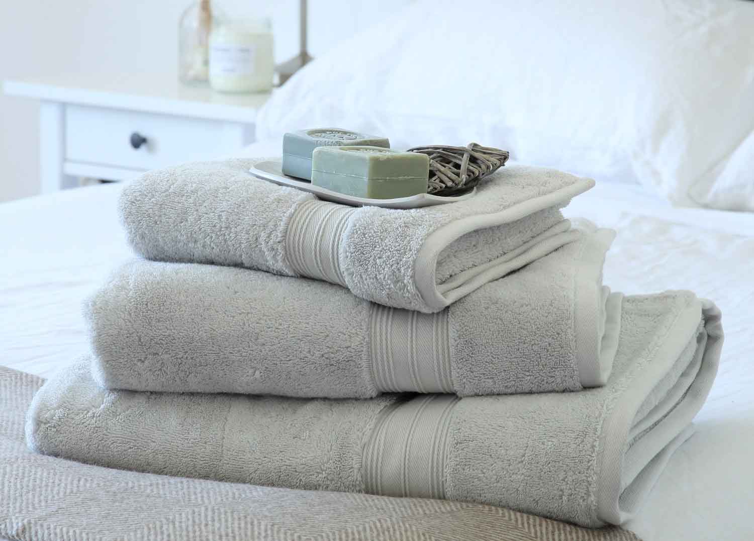 Luxury bath towel bundle on bed with soap
