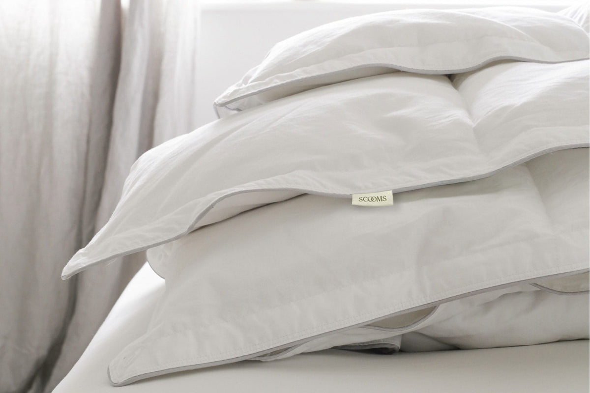 Goose down duvet folded on a bed showing Scooms brand label