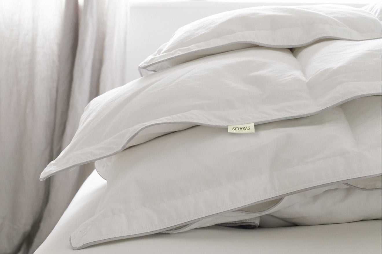 Goose down duvet folded on a bed showing Scooms brand label