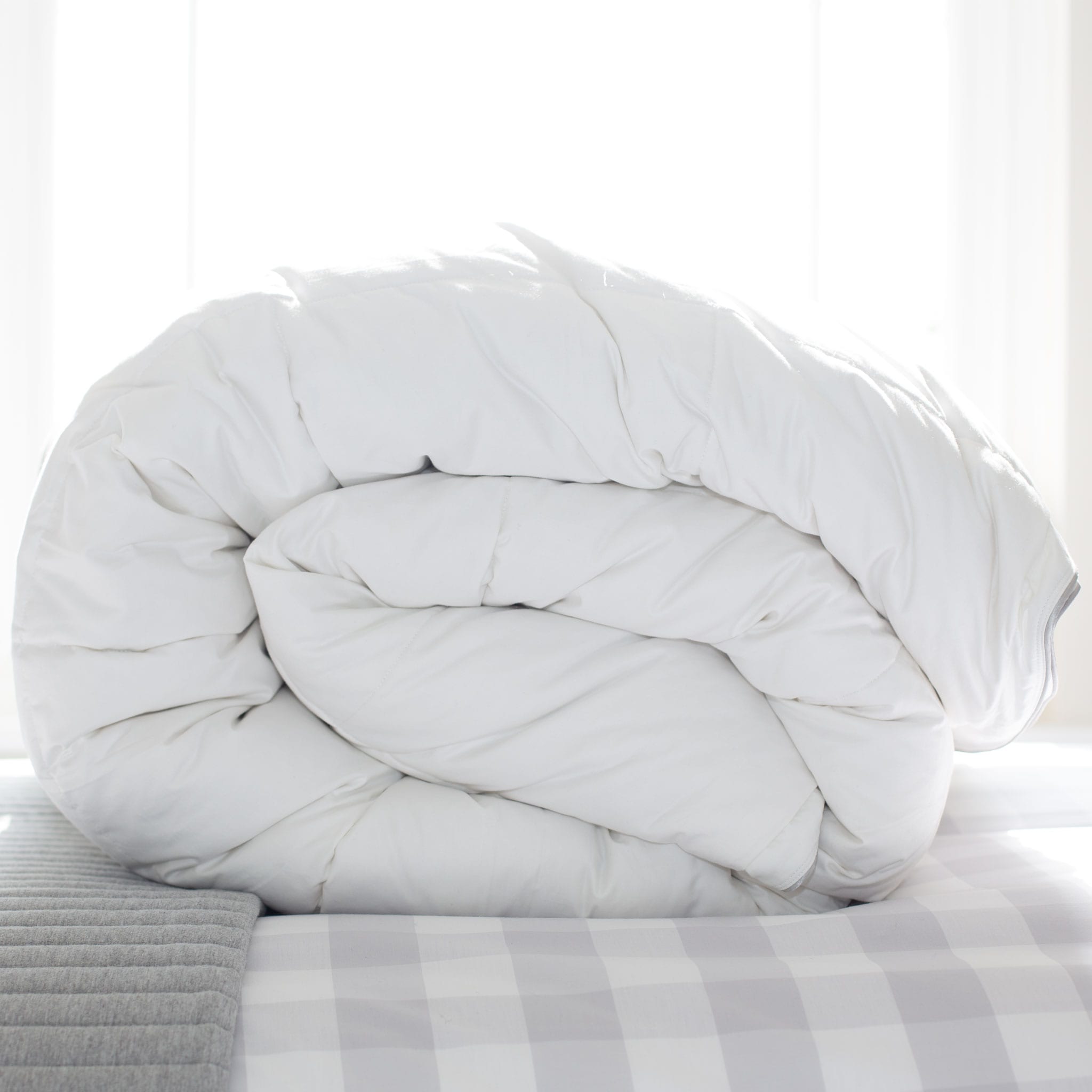 Hungarian goose down duvet, rolled, on bed