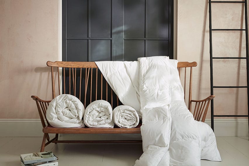 Various duvet togs rolled on a bench | Scooms