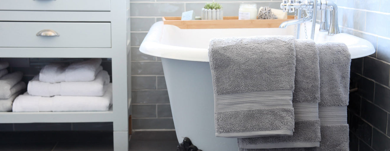 Bathroom scene with towels hanging over bath | Scooms
