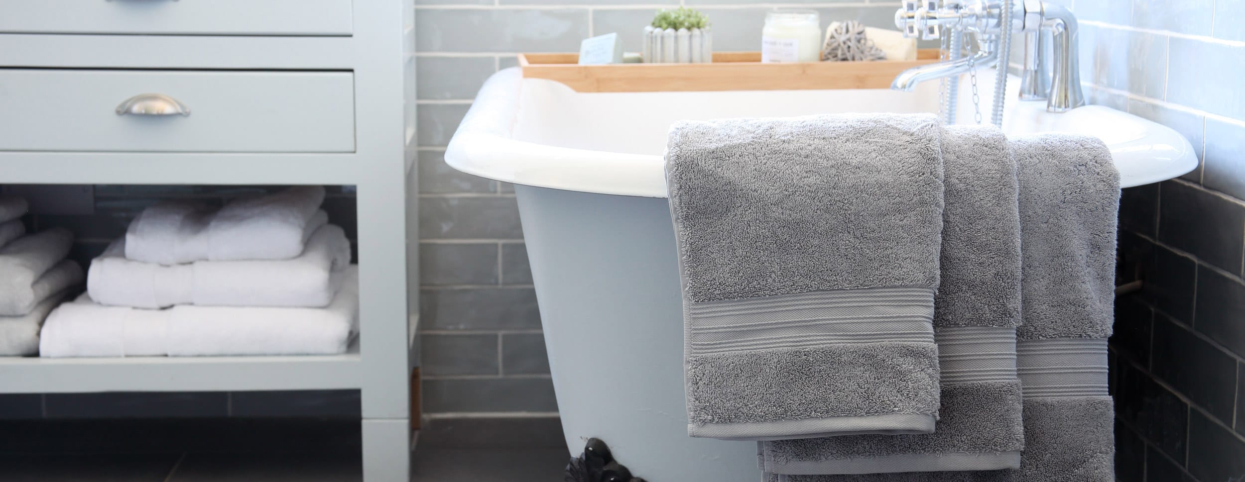Bathroom scene with towels hanging over bath | Scooms