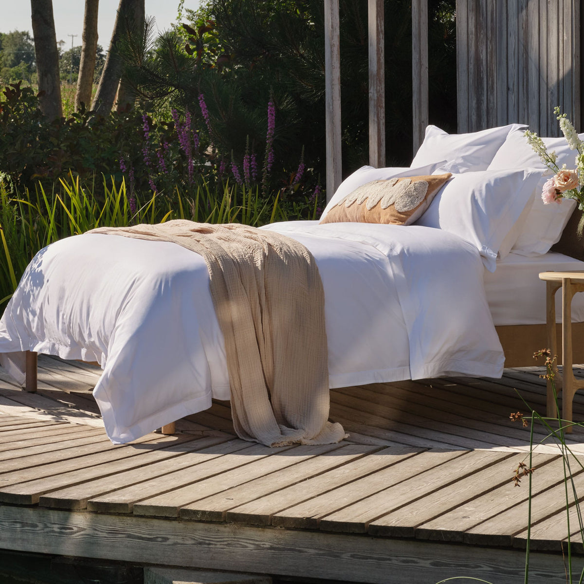 Egyptian cotton bedding on a bed outside. Scooms