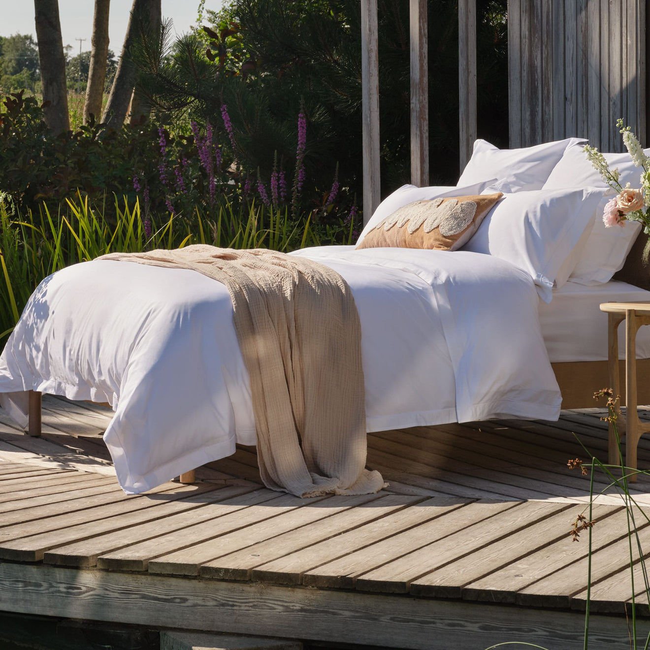Egyptian cotton bedding on a bed outside. Scooms