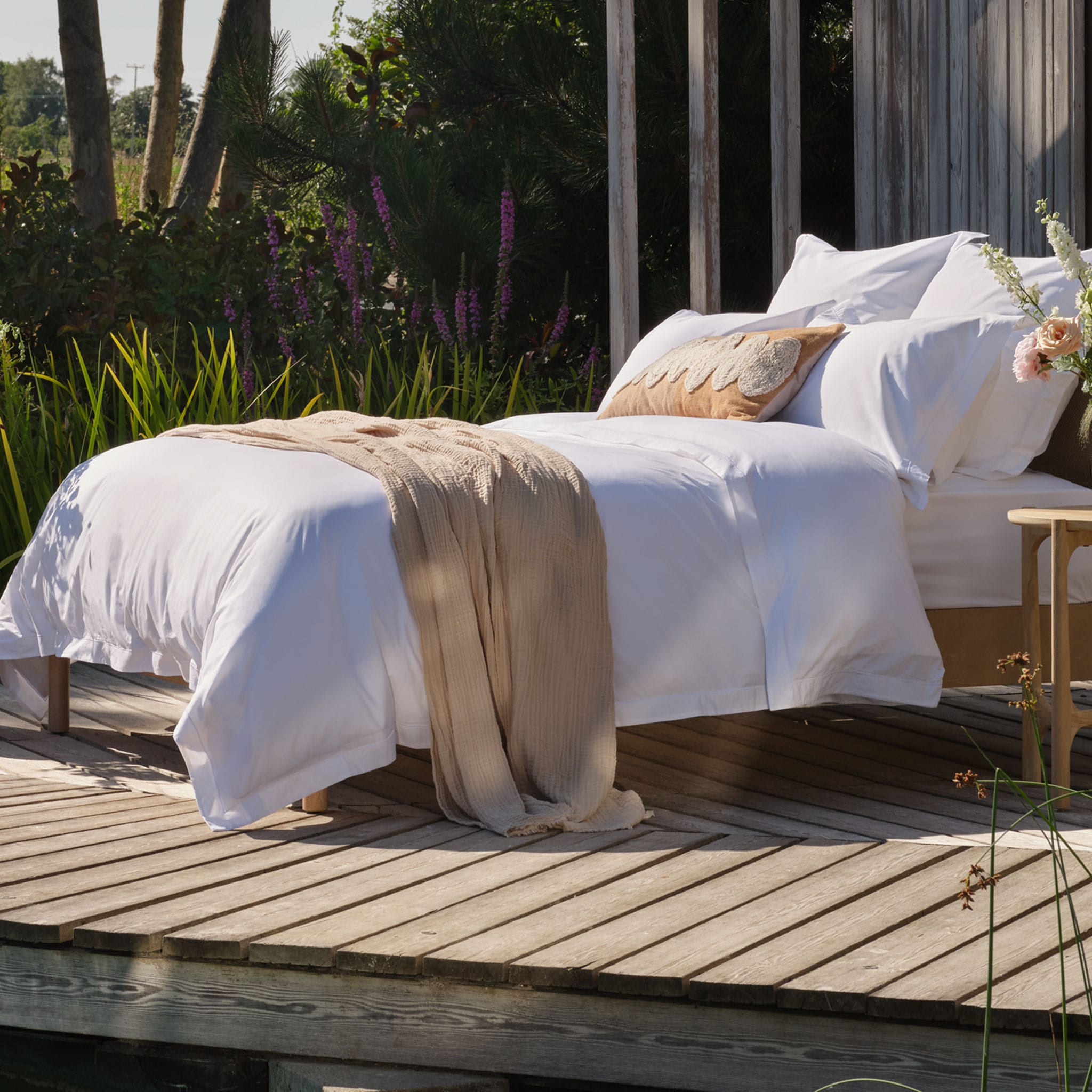Egyptian cotton bedding on a bed outside. Scooms