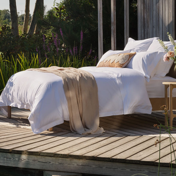 Egyptian cotton bedding on a bed outside. Scooms