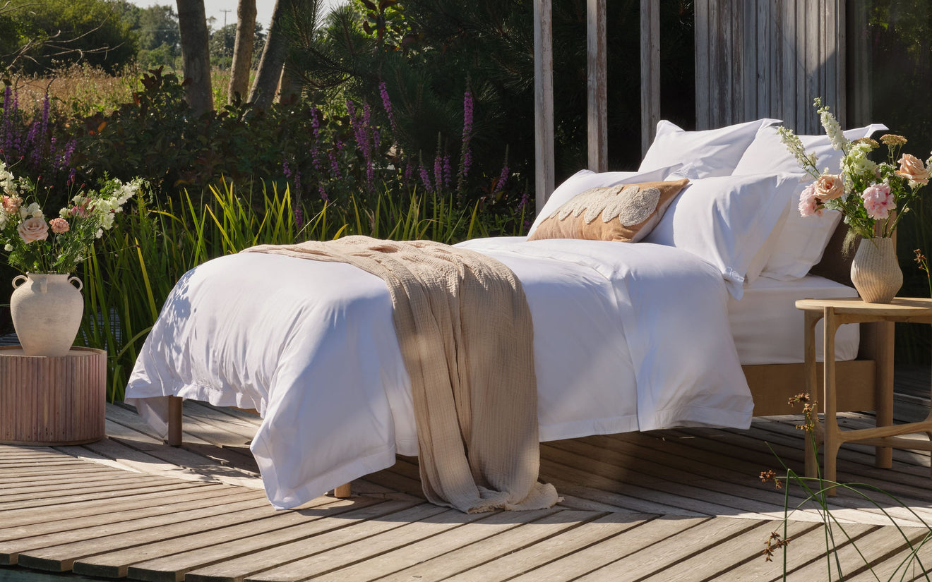 Luxury duvet and bedding on made bed outside. Scooms