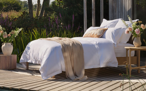 Luxury duvet and bedding on made bed outside. Scooms