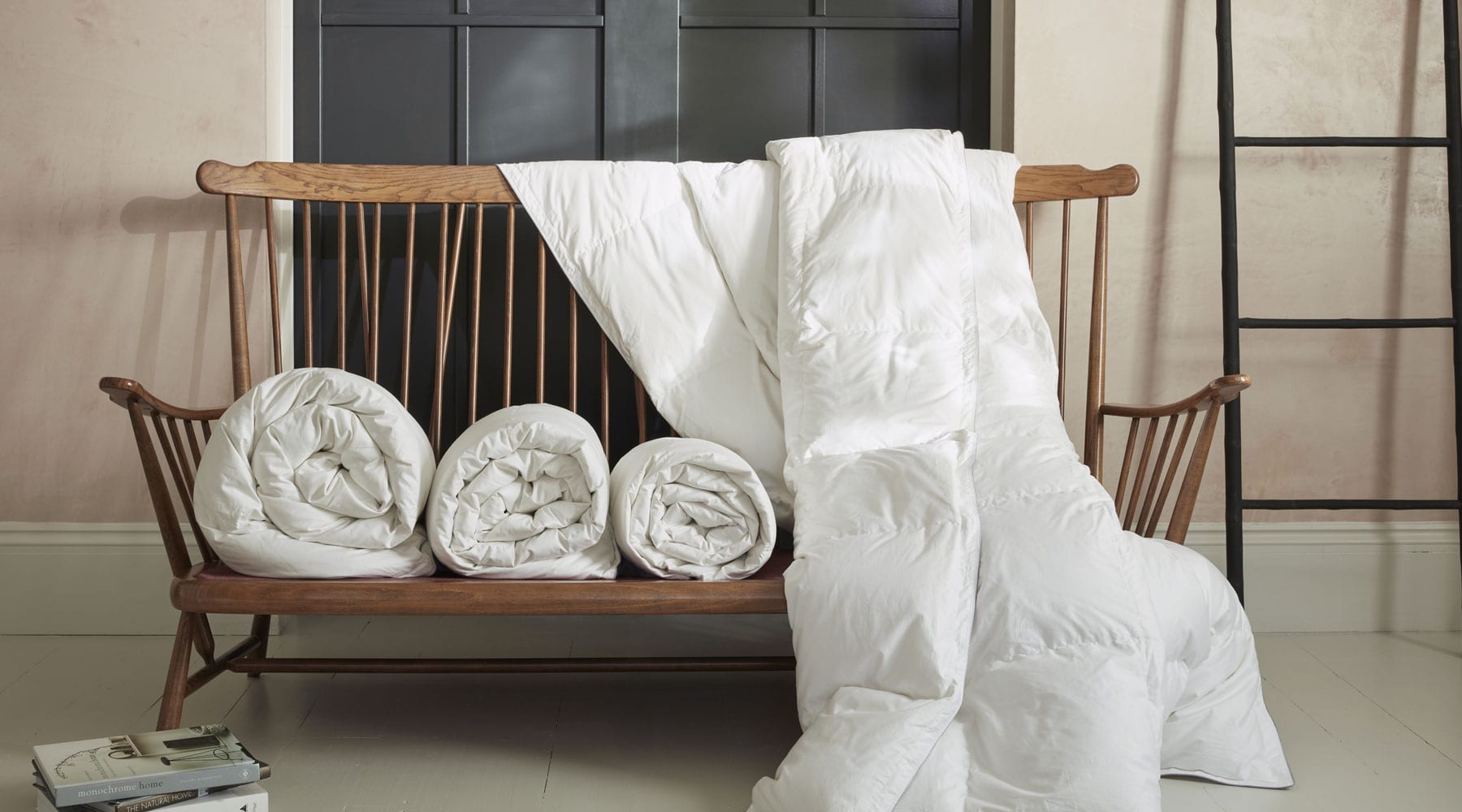 Luxury Scooms Hungarian goose down duvets on a wooden bench with a neutral background