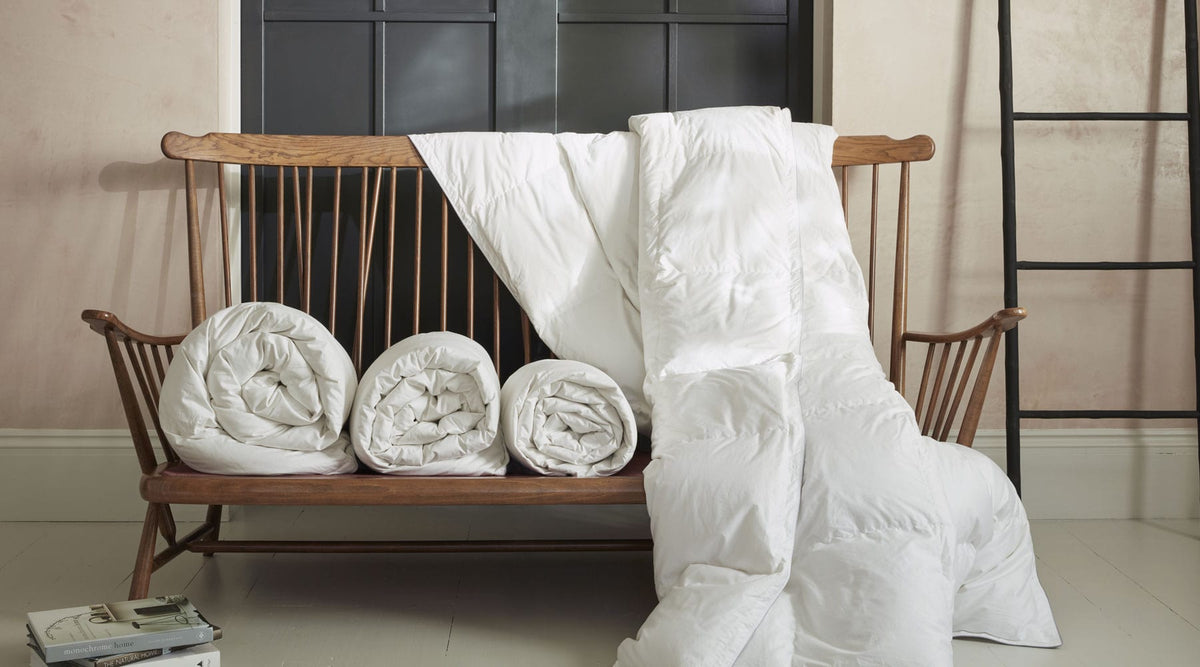 duvet rolled and draped on a wooden bench