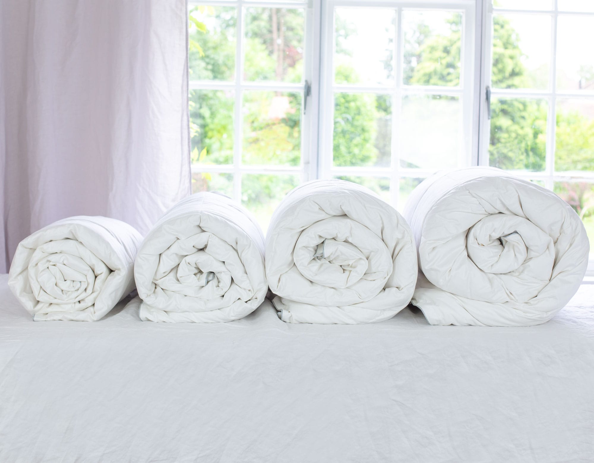 Rolled duvets showing different togs, 2.5, 4.5, 9 & 13.5
