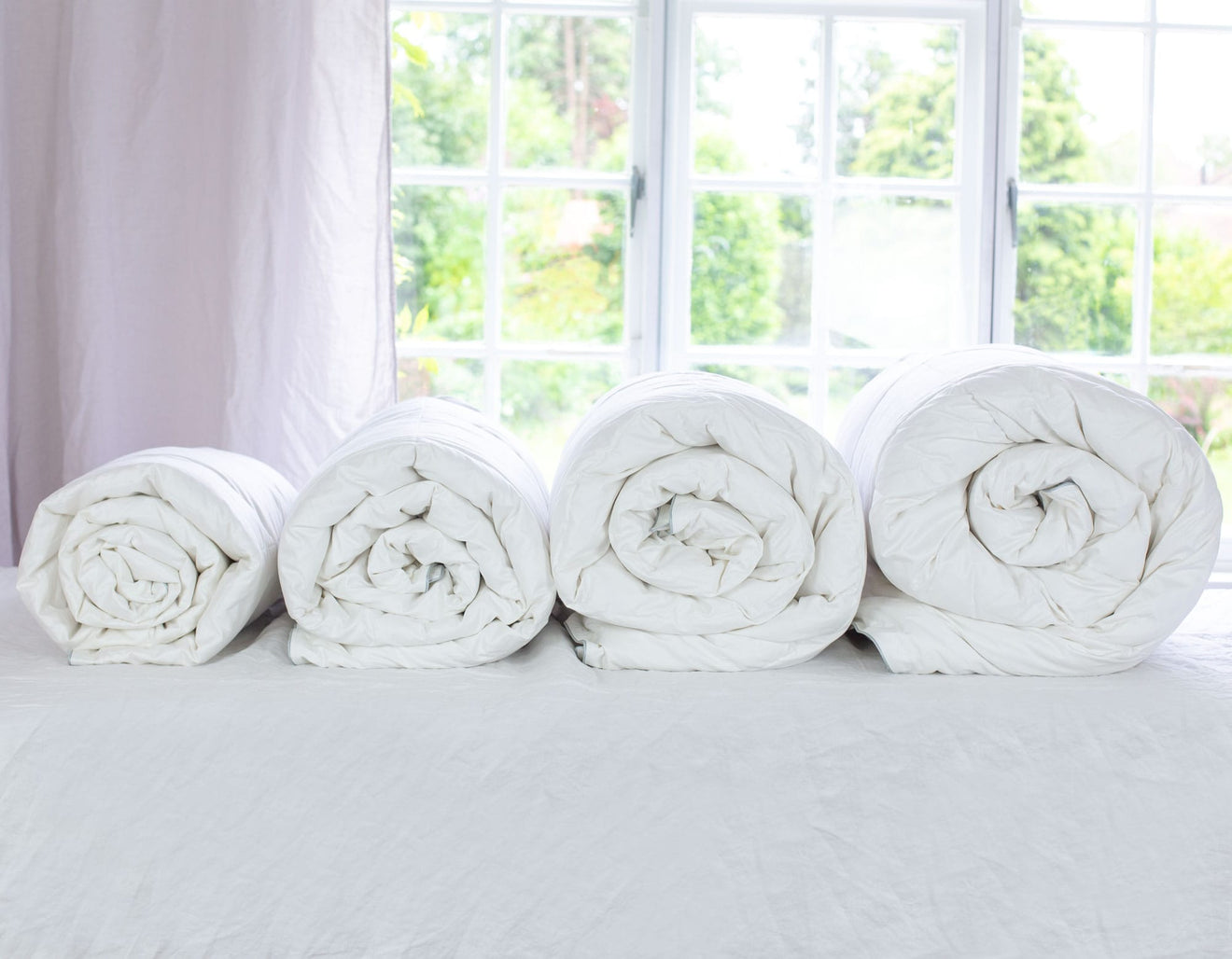 Rolled duvets showing different togs, 2.5, 4.5, 9 & 13.5