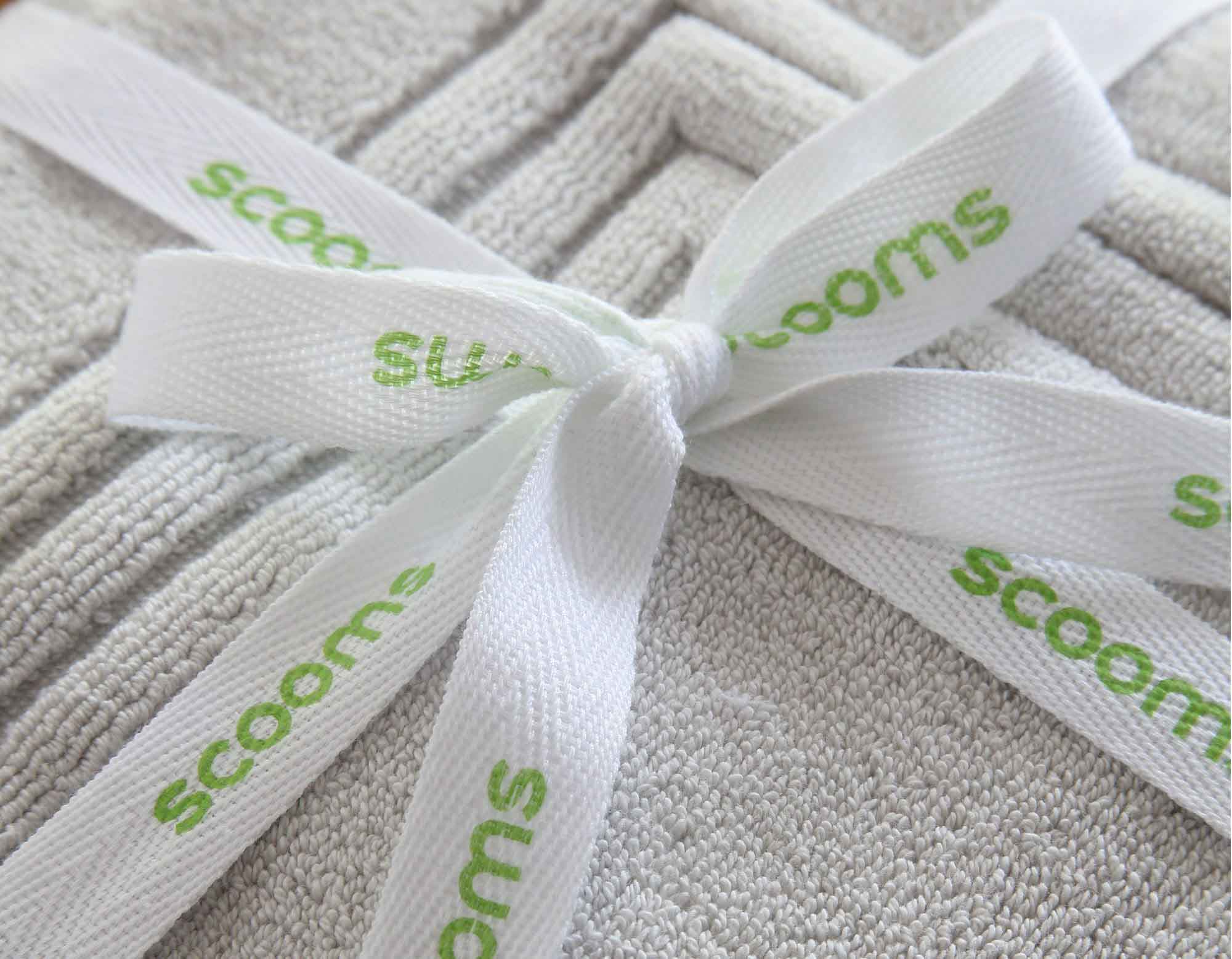 Grey bath mat tied with scooms branded ribbon