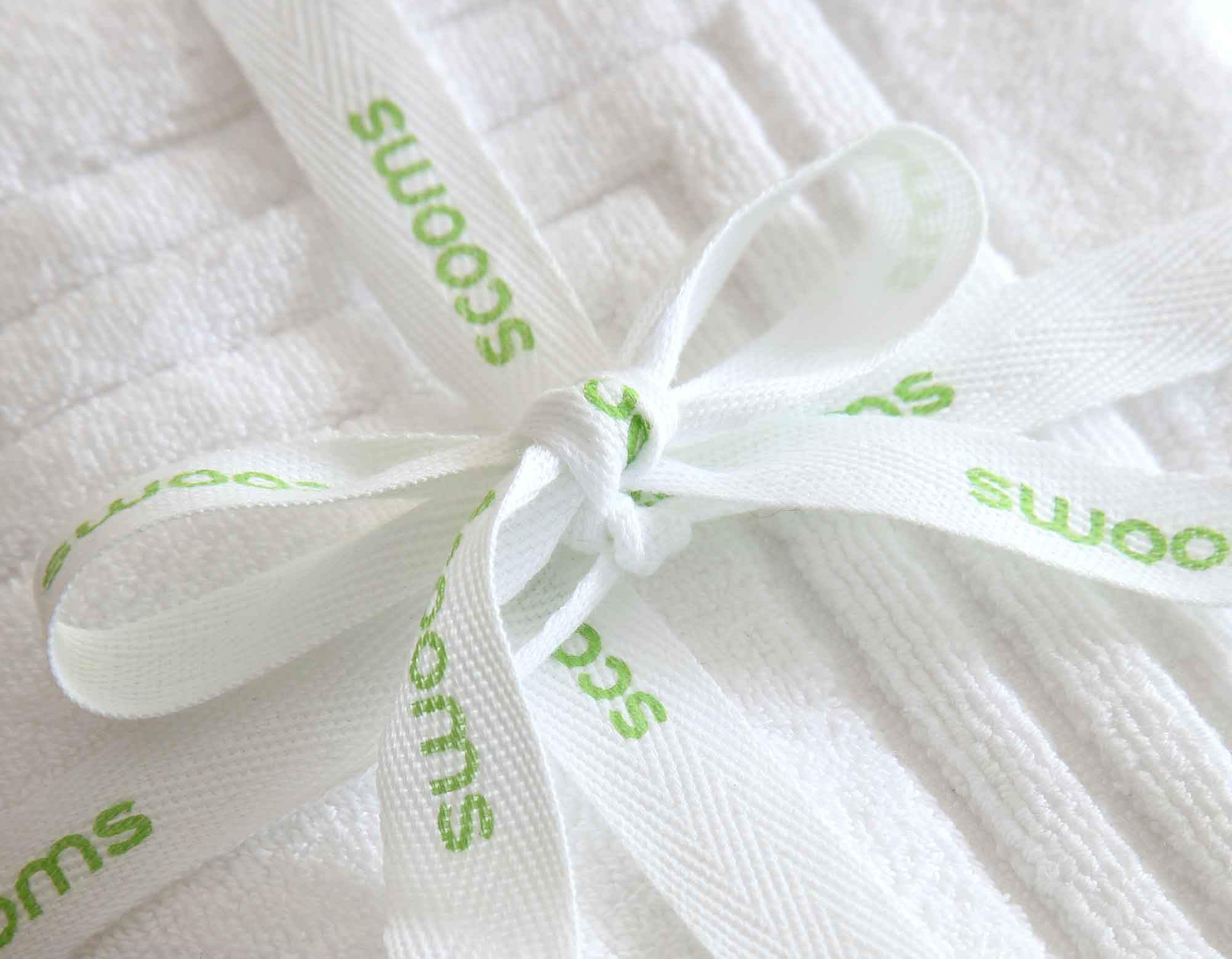 White bath mat close up tied with scooms branded ribbon