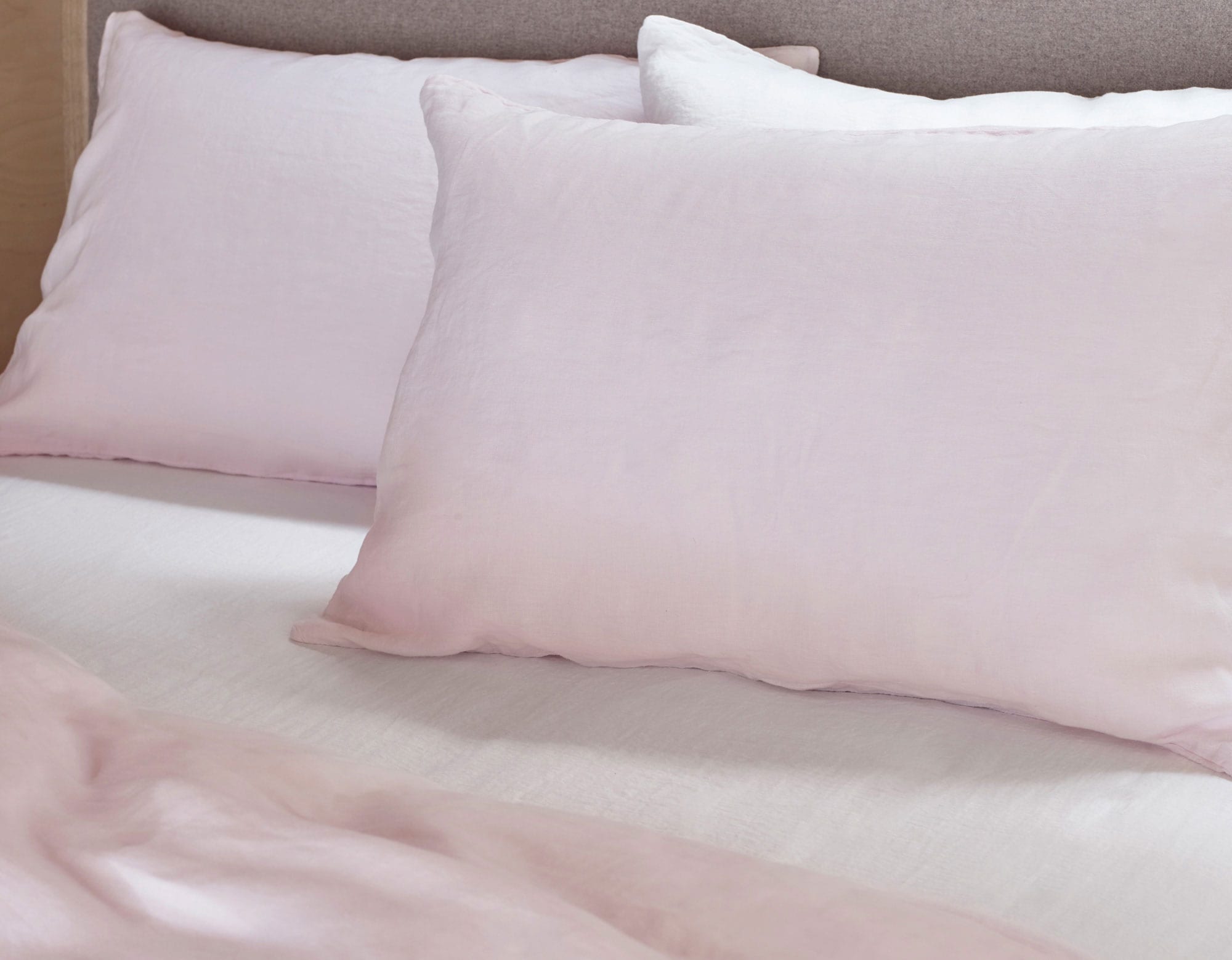 Pink linen bedding on made bed