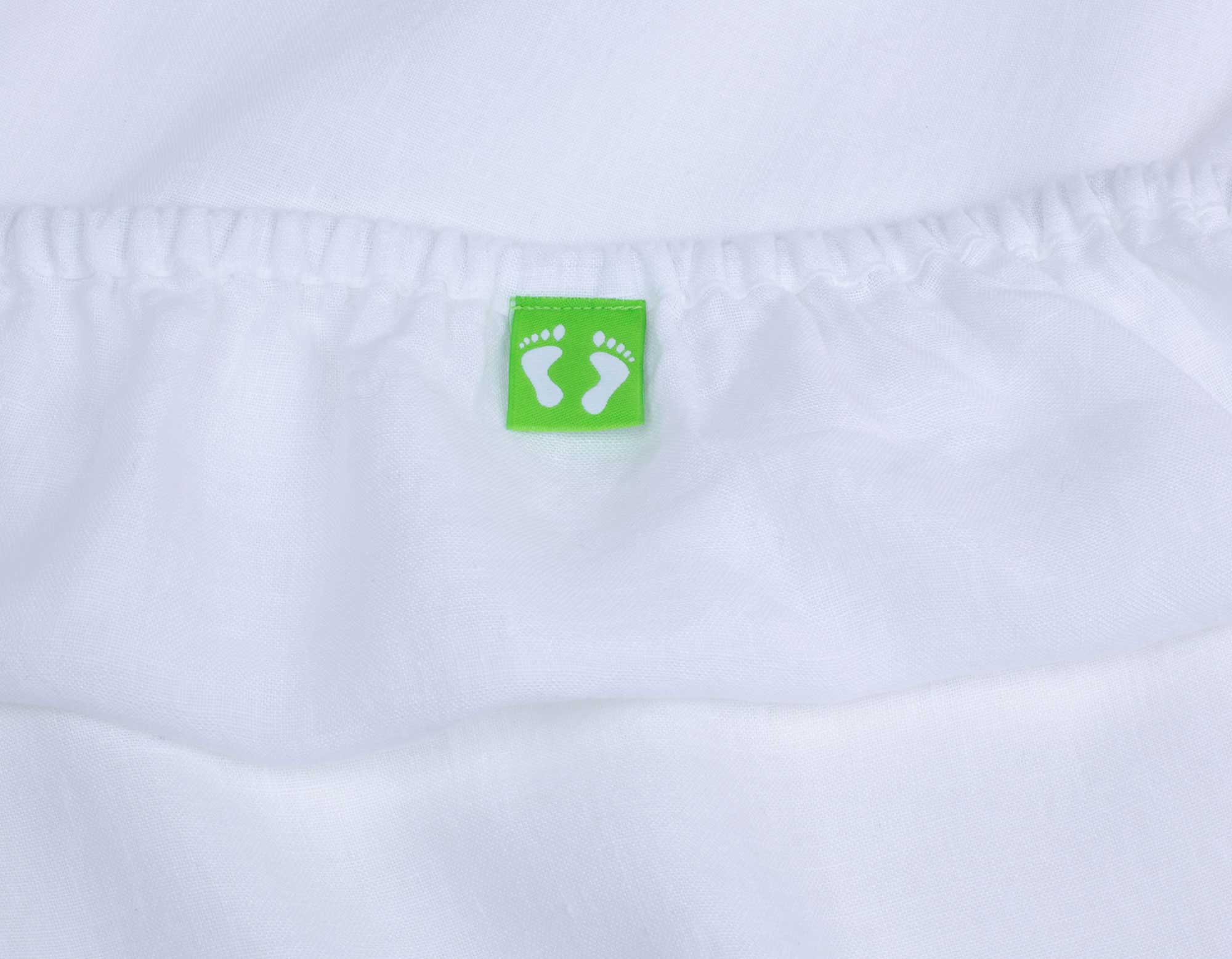 Double white linen fitted sheet showing scooms foot label and elastic edging