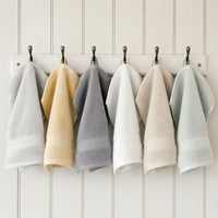 Egyptian cotton face cloths in grey, white, green, natural and creme hanging in bathroom | Scooms