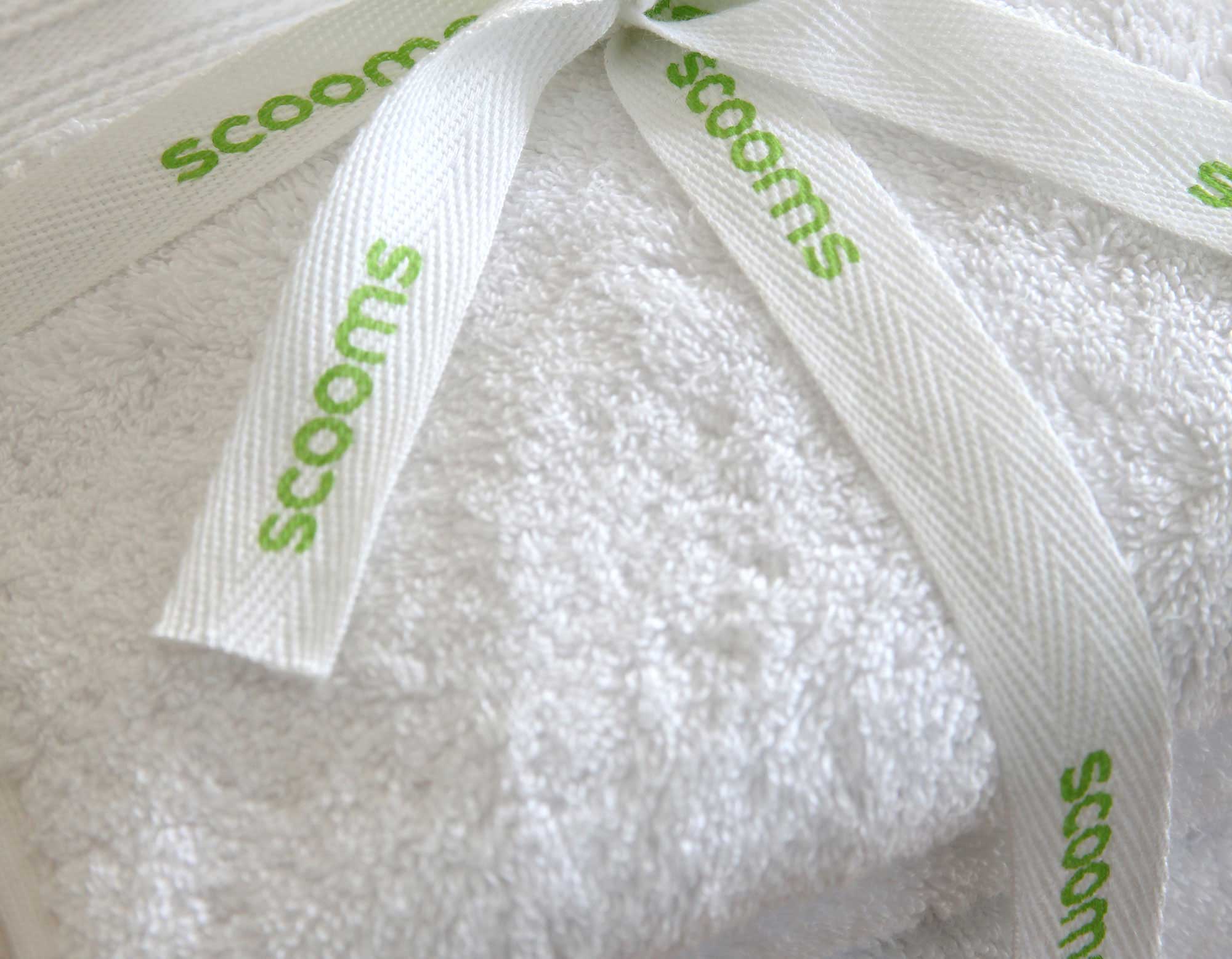 White cotton bath sheet folded and tied with scooms branded ribbon