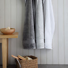 Grey and white Egyptian cotton towels hanging in a bathroom. Scooms