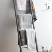 Grey and white Egyptian cotton towels handing from a ladder. Scooms