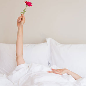 Girl in bed holding a rose. Scooms