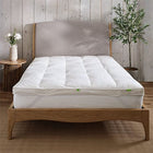 Hungarian feather and down mattress topper on a bed showing the straps to attach it to the mattress,. Scooms