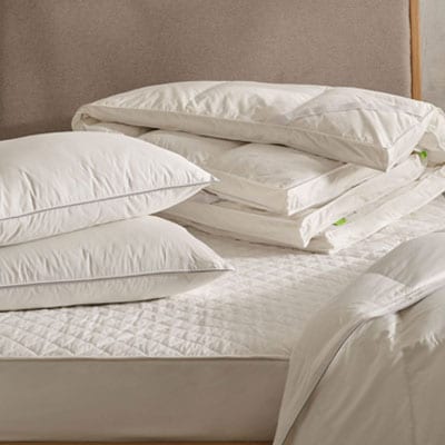 Hungarian goose down pillows, duvet, topper on bed with cotton mattress protector. Scooms