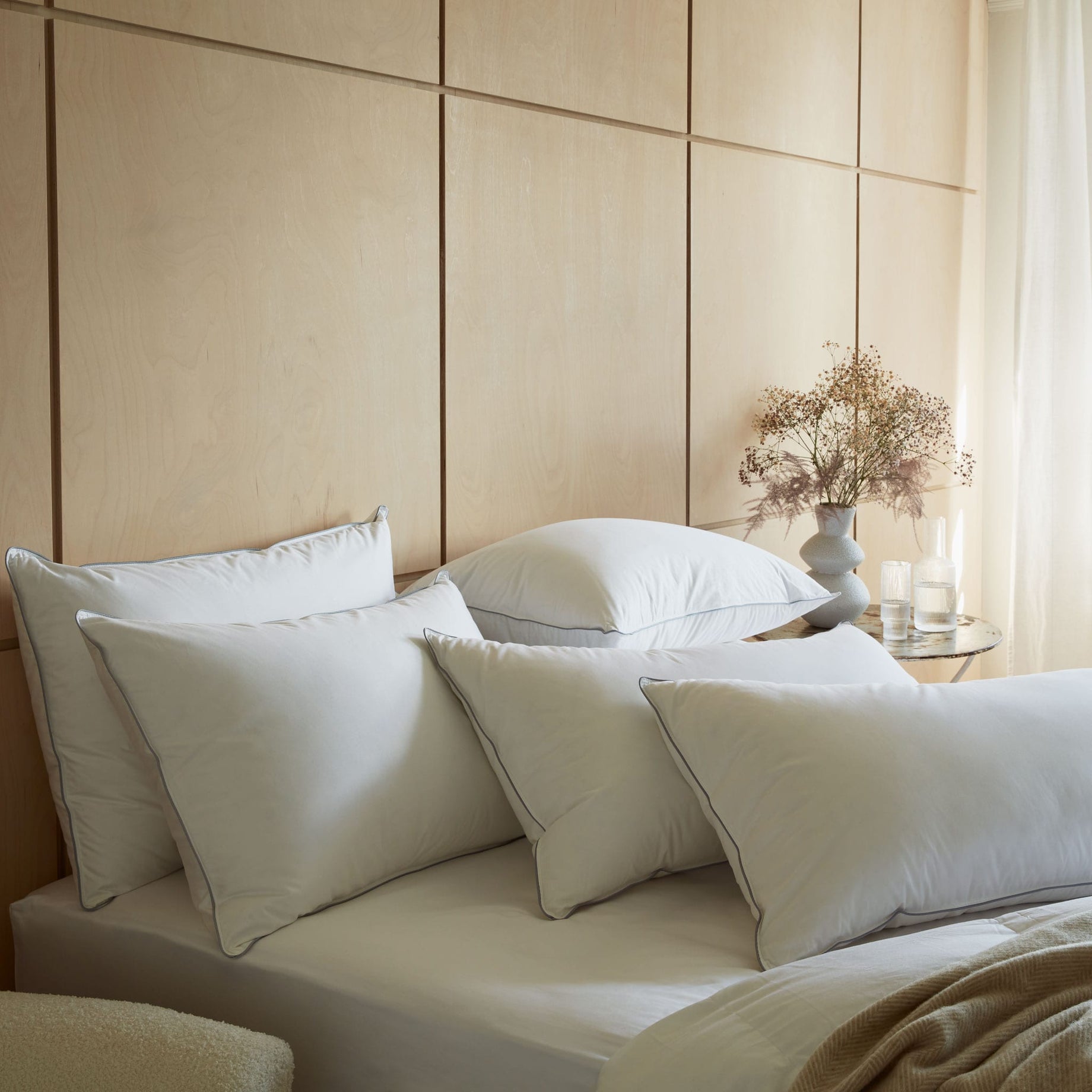 Pile of Hungarian goose down pillows on a bed. Scooms