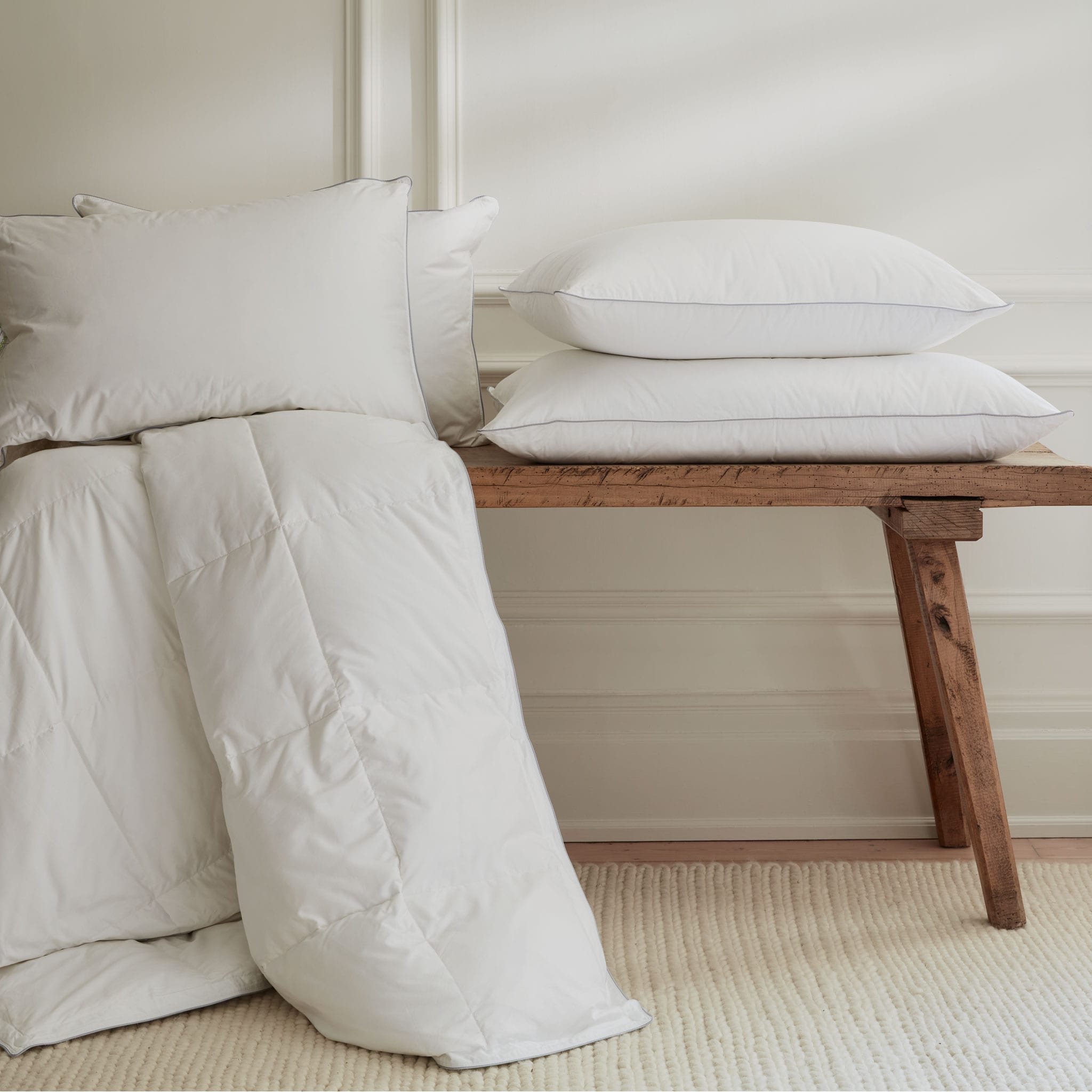 Down duvet and pillows on a wooden bench. Scooms