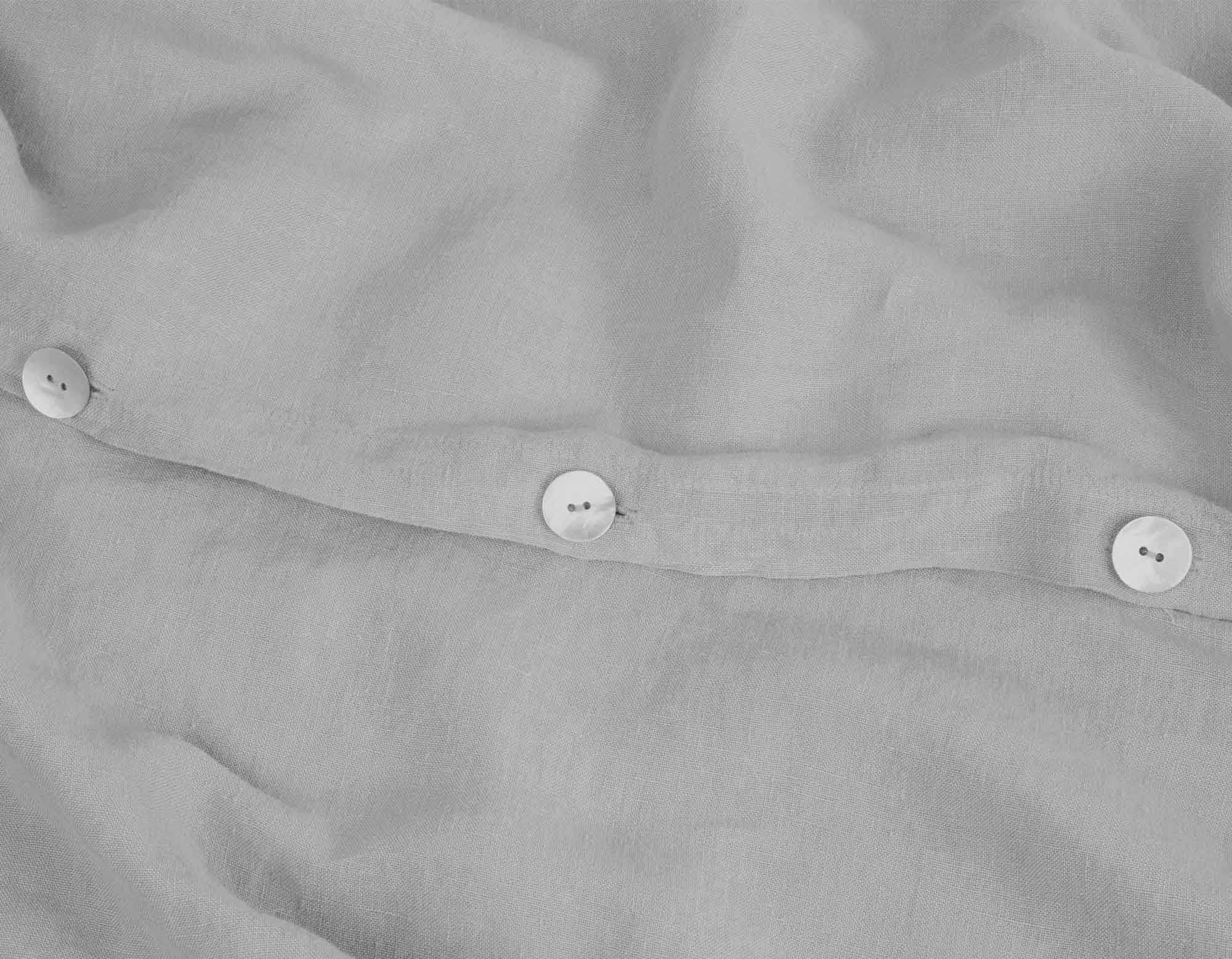 Grey linen bedding king size with close up of mother or pearl buttons