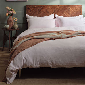 Pink linen bedding set on a bed. Scooms