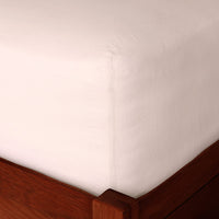 Pink linen fitted sheet on a mattress, corner detail. Scooms