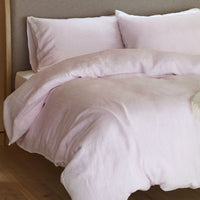 Pink linen bedding on a bed. Scooms