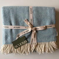Herringbone-patterned blue Merino lambswool throw with 'Scooms' branding.