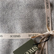 Close-up of a herringbone-patterned grey coloured Merino lambswool throw with 'Scooms' branding.