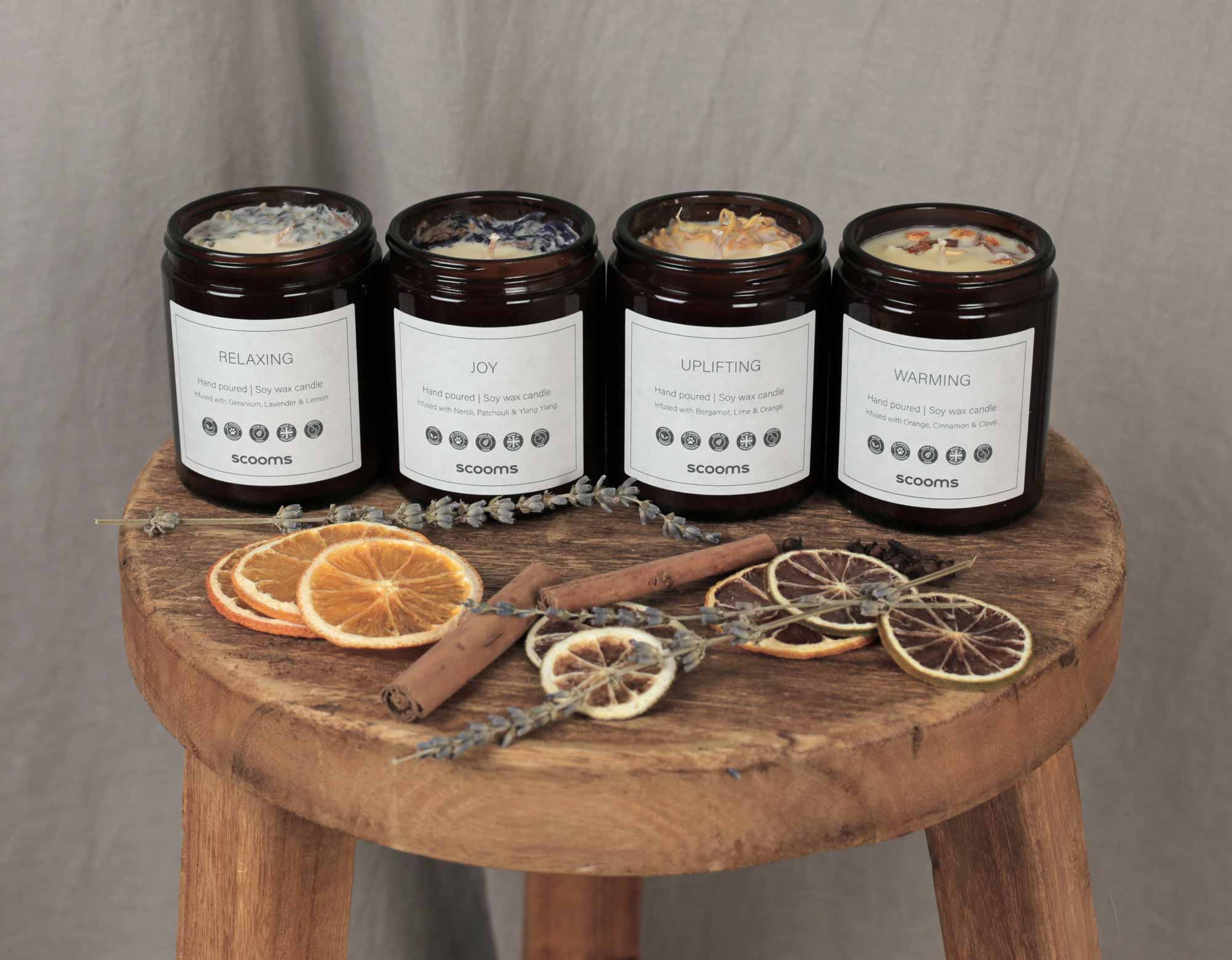 4 naturally scented candles with ingredients on a stool