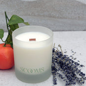 Natural scented candle in a frosted glass jar with an orange, lavender and leaves | Scooms