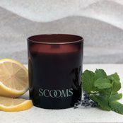 Natural scented candle in an amber glass jar next to a lemon, mint and lavender | Scooms