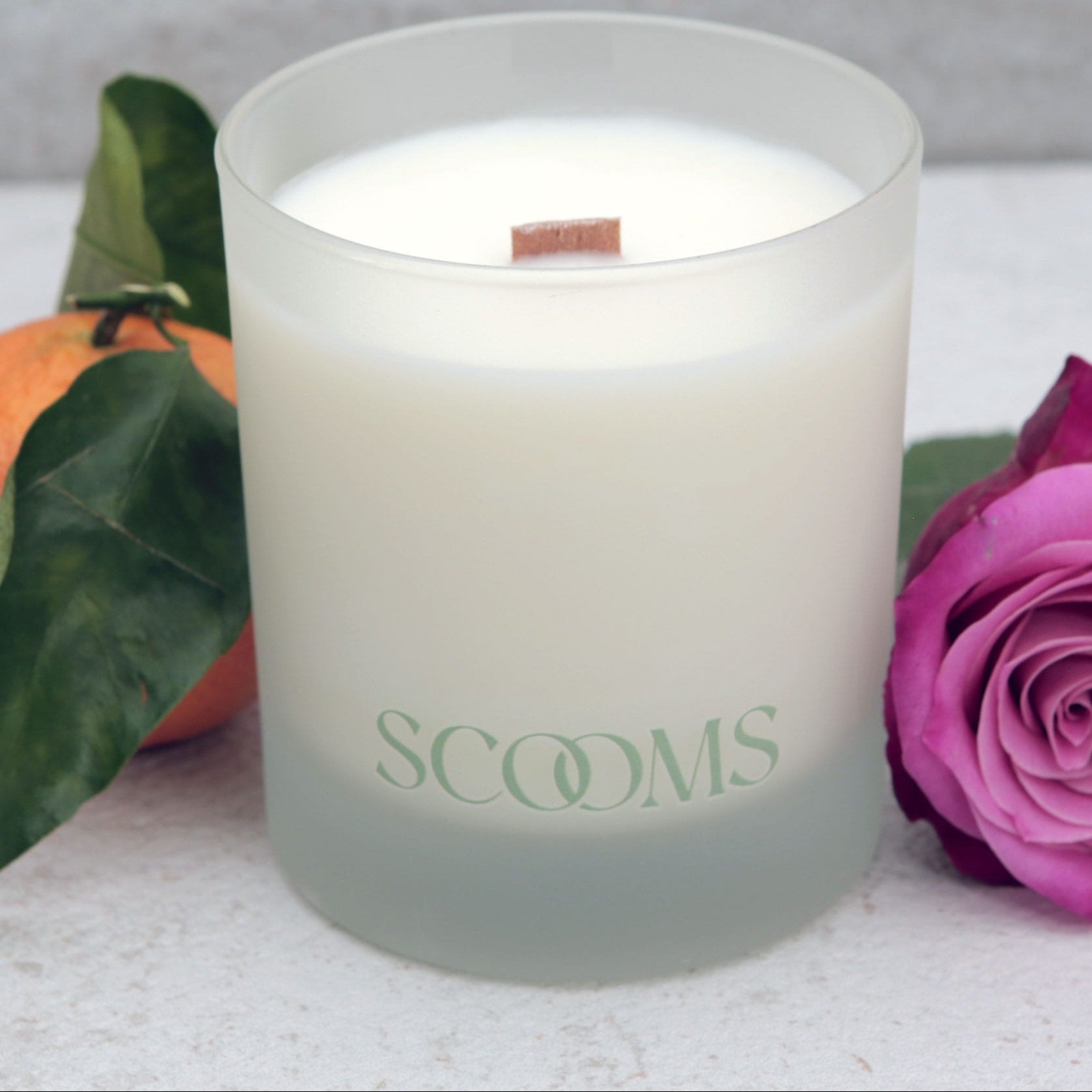 Natural scented candle in a frosted reusable glass jar with an orange, rose and leaves | Scooms