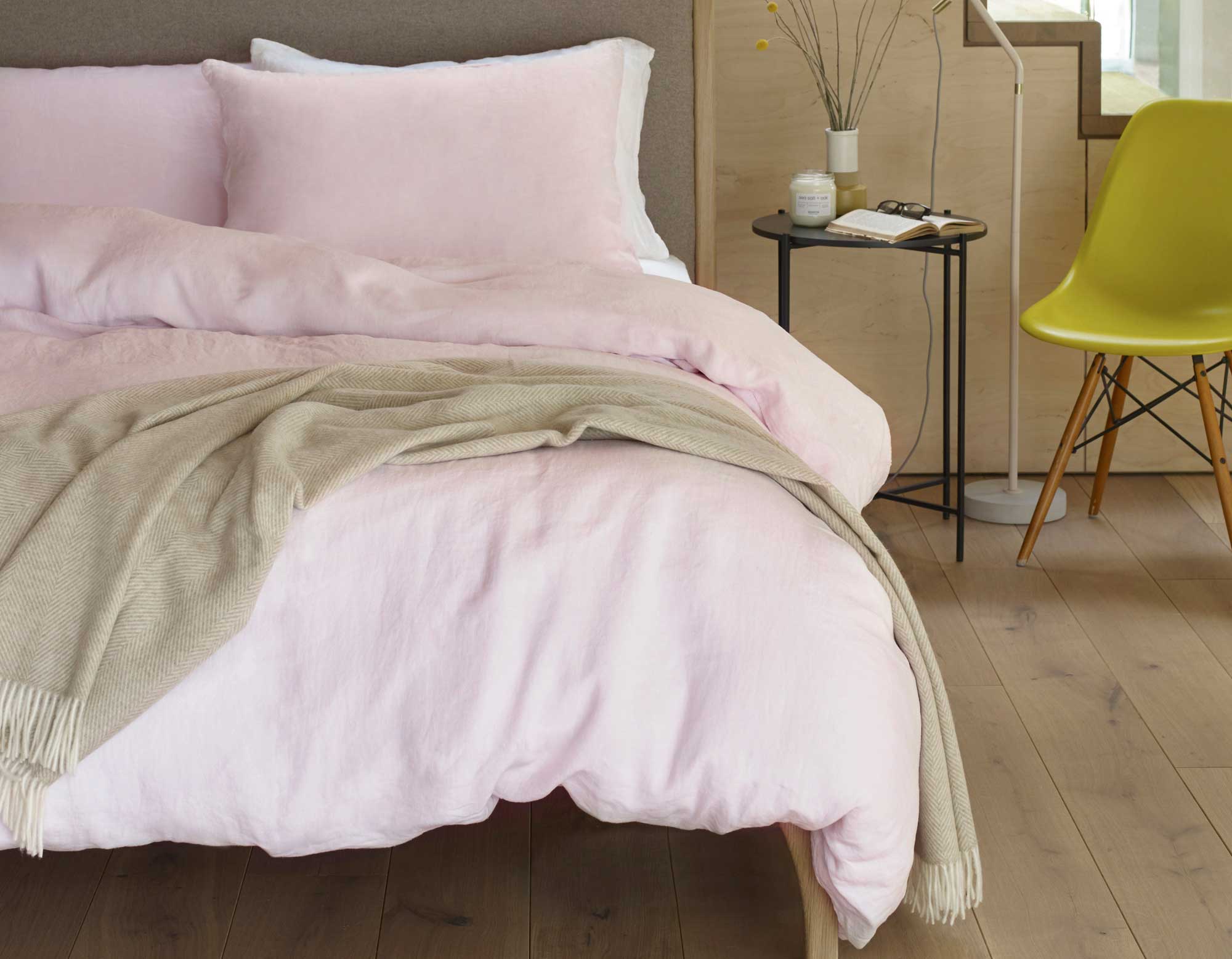 Pink linen pillowcases and duvet cover on bed in modern bedroom 