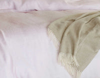 Single linen fitted sheet in pink with wool throw