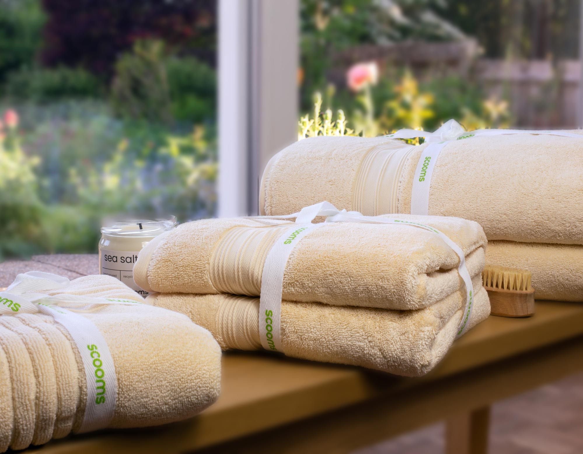 Egyptian Cotton Creme Towel Bales Tied With Scooms Ribbon On Wooden Bench In Front Of Window
