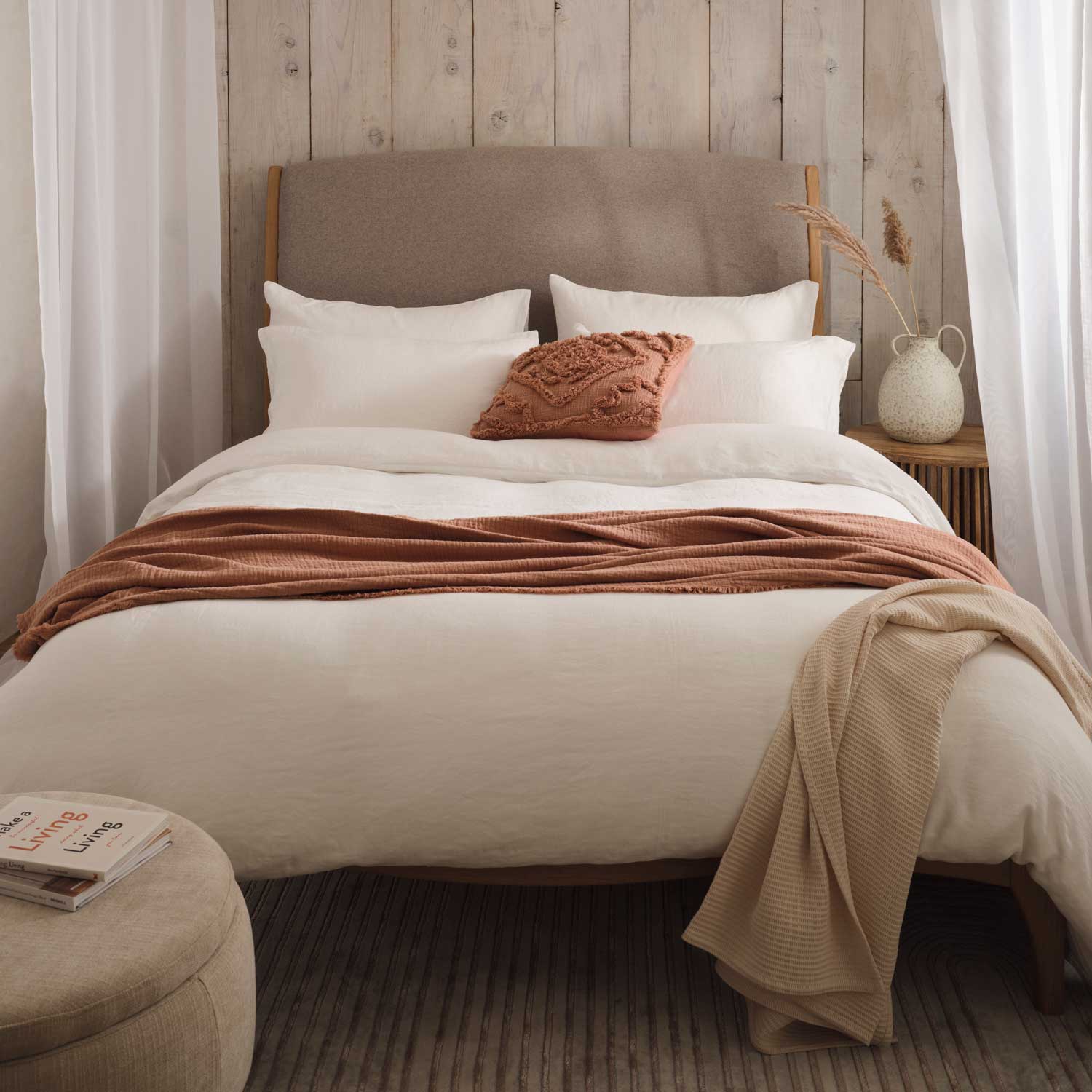 Linen bedding on bed with accessories