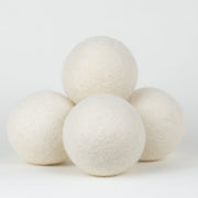 4 wool dryer balls in a pile on a white background. Scooms