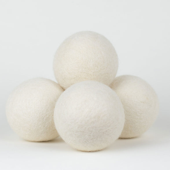 4 wool dryer balls in a pile on a white background. Scooms